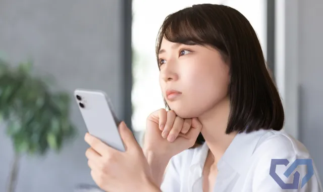 スマホを片手に悩む人