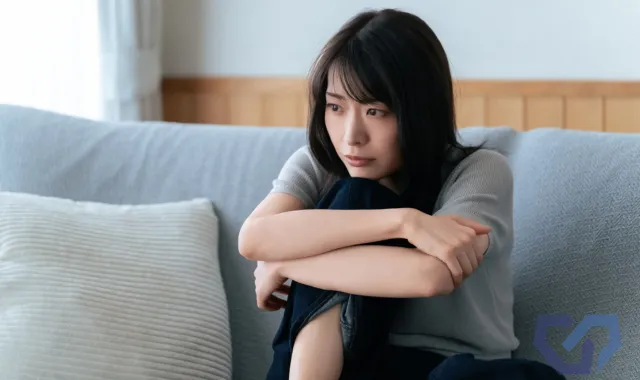 膝を抱える女性